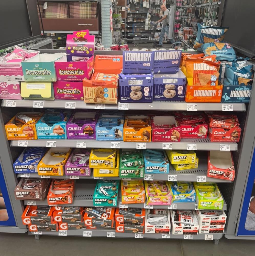 A crowded retail shelf of protein bars